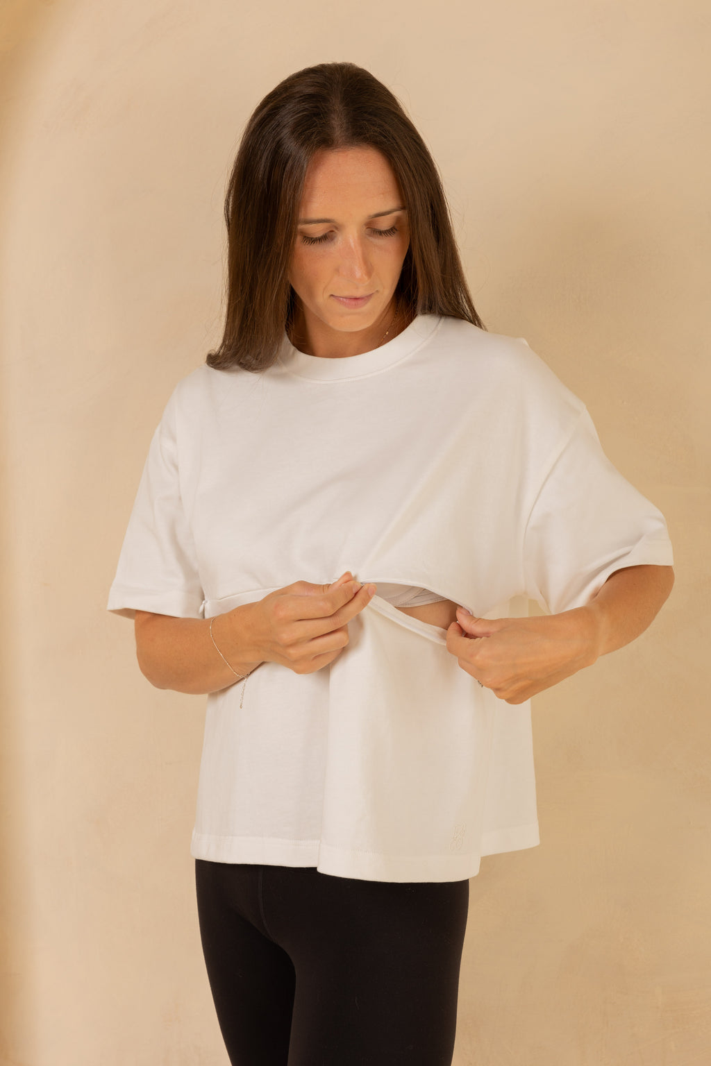 Woman wearing a white t-shirt against a beige background